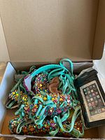 Box containing turquoise rhinestone costume pieces