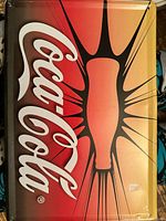 metal sign with Coke bottle burst graphic