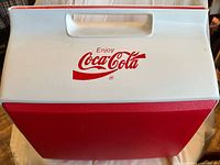 Top view showing white lid with Enjoy Coca-Cola logo and handle
