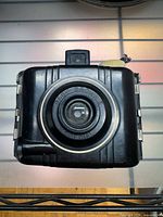 Front view showing lens, gold ring, ribbed Bakelite body