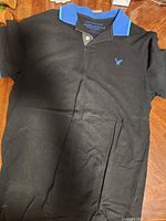 Full view of black polo shirt front