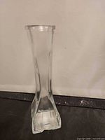 Full view of clear glass bud vase, square base visible