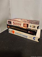 Three VHS tapes stacked: Buddy, The Mothman Prophecies, Forrest Gump