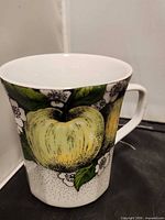 Front view of mug showing apple and blossoms design