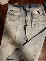 Full view of front of jeans showing wash, distressing and overall state