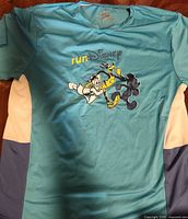 Front view of teal runDisney shirt with character graphic