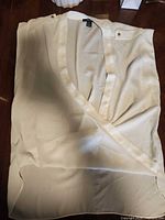 Full view of cream sleeveless wrap blouse