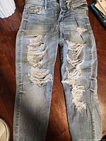 Full front view of jeans showing heavy distressing