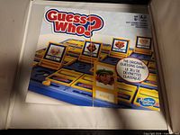 Front of Guess Who? game box displaying branding, components and age rating