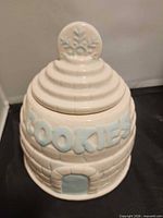 Full view of igloo cookie jar with lid on showing text and snowflake finial