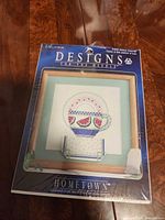 Front of sealed cross-stitch kit showing design and branding
