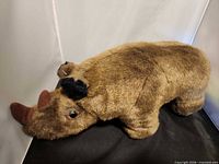 Full left-side view of brown rhinoceros plush
