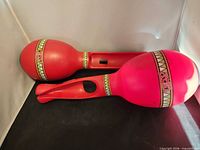 Two red Samba de Amigo maraca holders side by side