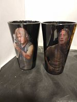 Front view of both black character tumblers