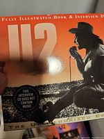 Front cover showing title, Bono image, sticker noting interview CD