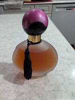 Front view of frosted bottle with tassel and cap