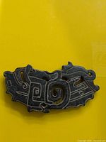 Front view of black jade carved pendant showing motifs and colour
