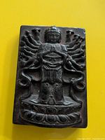 Front of pendant showing deity motif and wear