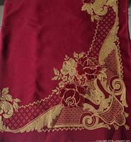 Full view of burgundy table accent showing gold floral and scroll design