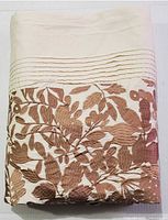 Duvet cover folded showing copper-tone botanical accent and pintuck detail