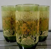 Three of the avocado green tumblers showing gold floral lace decoration