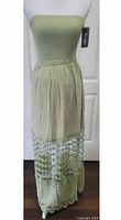 Full front view of sage green sundress on mannequin