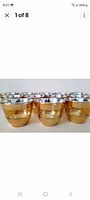 Front view showing multiple gold-finished glass sake cups with silver rims