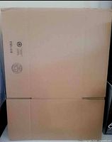 Front view of flat corrugated cardboard box with manufacturer stamp visible