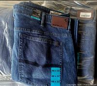 Front view of folded jeans showing leather patch, size sticker and tags
