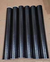 six black mailing tubes aligned side by side