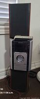 Full view of stereo unit stacked between two speakers with remote on top
