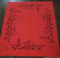 Full view of red tablecloth laid flat showing complete design