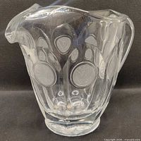 Front view of clear Coin pattern pitcher showing medallions and shape