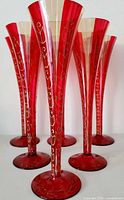Front view of six red and gold champagne flutes