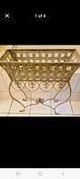 Full view of sage green wrought iron plant stand showing lattice top and scroll legs