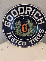 Front view of round Goodrich Tested Tires sign