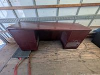 Full view of wooden double pedestal desk on truck floor