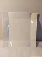 Top view of white square platter showing surface and flared edges