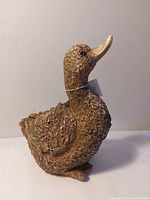 Left front view showing full duck figurine, texture and size reference tag