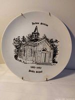 Front view of commemorative plate showing full illustration and hanger