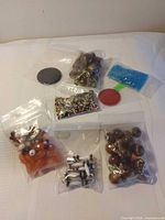 Overview of eight zip bags of assorted beads and findings plus two discs