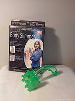 Retail box and green roller massager displayed together