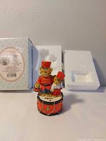 Front view of figurine with box and inserts