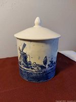 Front view of Delft covered dish with lid on, showing windmill scene
