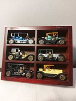 front view of full wooden case holding six antique style model cars