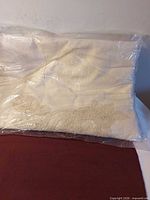 Full view of packaged ecru duvet cover with lace detail visible