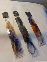 Three packaged feather extensions laid out