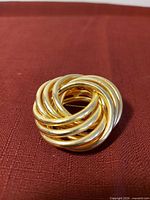 Front view of gold-tone knot brooch