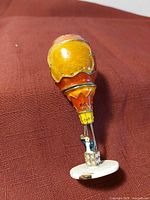 Overall view of hot-air-balloon jewelry holder lying on fabric