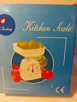Front of box showing image of scale with produce and Kitchen Scale text